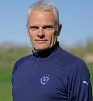 En man i 60-års åldern med kort grått hår och en flaggblå tröja med huva på sig.